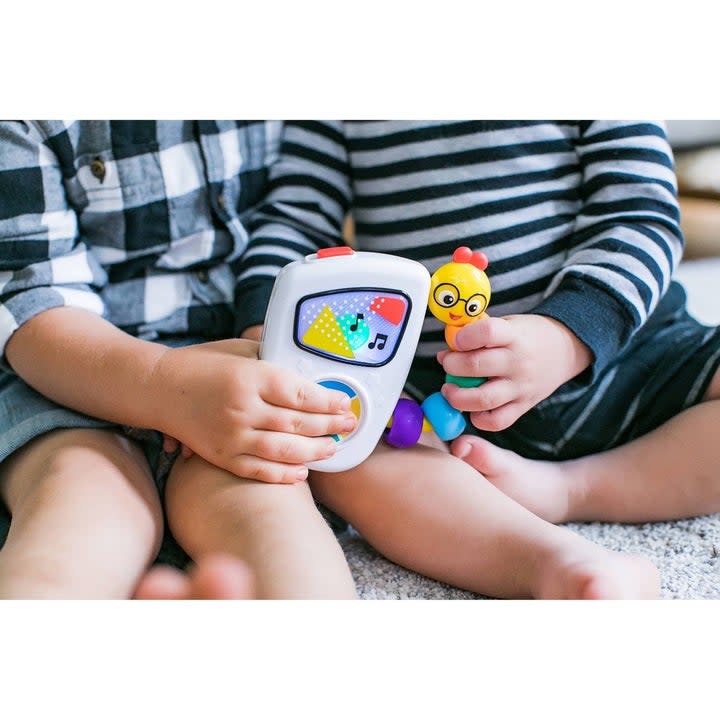 Two babies holding the Baby Einstein Take Along Tune