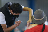 A medical worker injects a woman with a dose of the Russian COVID-19 vaccine Sputnik V at the Palacio de los Deportes, in the Iztacalco borough of Mexico City, Wednesday, Feb. 24, 2021. (AP Photo/Rebecca Blackwell)