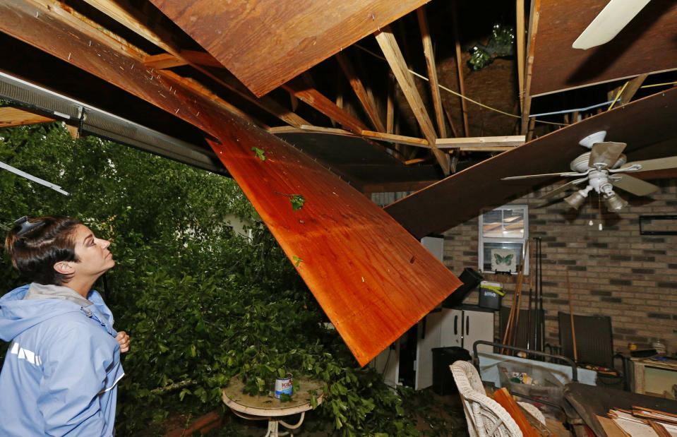 Sonya Banes looks at damage caused by a large oak tree that crashed through the ceiling of her mother's house in Learned, Miss., Thursday, April 18, 2019. Several homes were damaged by fallen trees in the tree lined community. Strong storms again roared across the South on Thursday, topping trees and leaving more than 100,000 people without power across Mississippi, Louisiana and Texas. (AP Photo/Rogelio V. Solis)