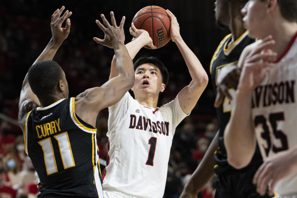 Davidson guard Hyunjung Lee (1) shootsover Virginia Commonwealth guard KeShawn Curry (11) during the first half of an NCAA college basketball game in Davidson, N.C., Wednesday, Jan. 26, 2022. (AP Photo/Jacob Kupferman)