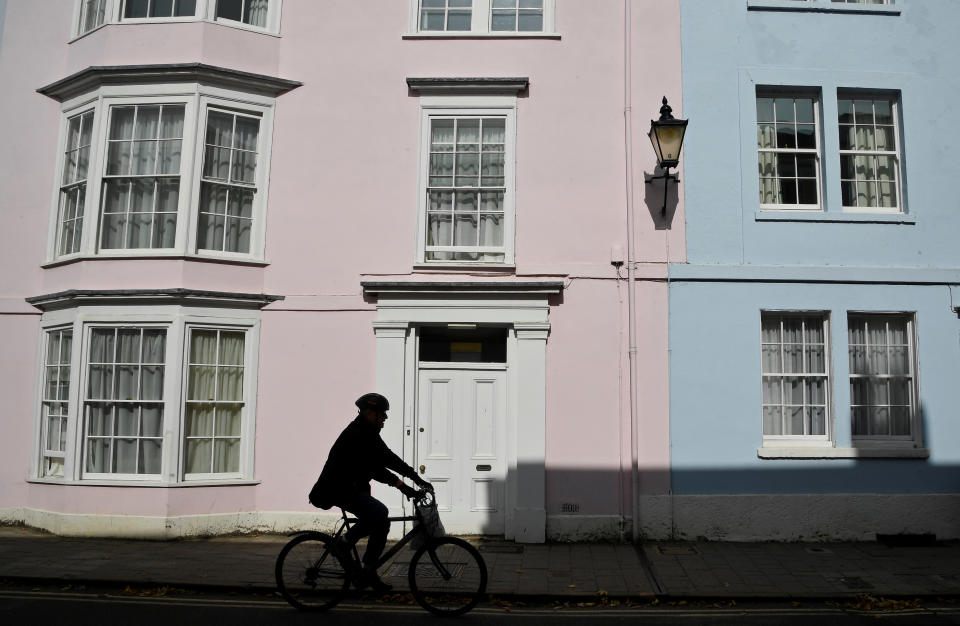 A man is silhouetted as he cycles through the city centre amidst the coronavirus disease (COVID-19) pandemic, in Oxford, Britain, September 17, 2020. REUTERS/Toby Melville