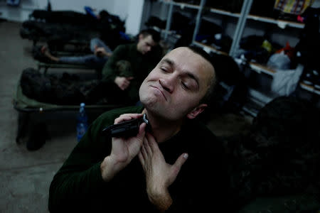 Recruit Marcin Wierzbicki, 44, a manager in an energy company, shaves during his 16-day basic training for Poland's Territorial Defence Forces, at a barrack in a military unit in Siedlce, Poland, December 14, 2017. REUTERS/Kacper Pempel/Files