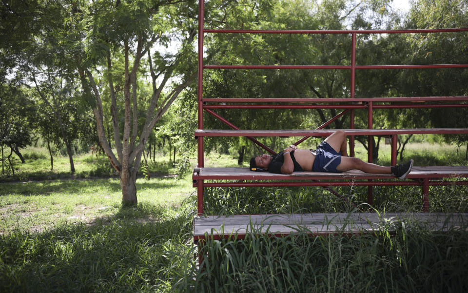 A migrant rests in a park near the entrance to the Puerta Mexico bridge that crosses over the Rio Grande river in Matamoros, Mexico, Thursday, Aug. 1, 2019, on the border with Brownsville, Texas. The U.S. is sending back groups of 50 to 100 migrants almost daily to Matamoros, according to the state immigration office. (AP Photo/Emilio Espejel)