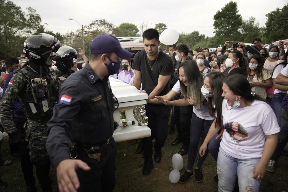 Relatives of Leidy Vanessa Luna Villalba react as the coffin that contain her remains arrives outside her home, in Eugenio Garay, Paraguay, Tuesday, July 13, 2021. Luna Villalba, a nanny employed by the sister of Paraguay's first lady Silvana Lopez Moreira, was among those who died in the Champlain Towers South condominium collapse in Surfside, Florida on June 24. (AP Photo/Jorge Saenz)