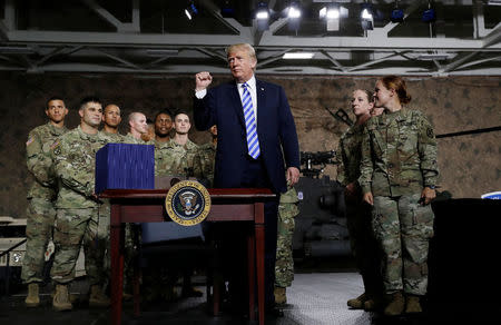U.S. President Donald Trump pumps his fist after signing the National Defense Authorization Act in front of soldiers from the U.S. Army's 10th Mountain Division at Fort Drum, New York, U.S., August 13, 2018. REUTERS/Carlos Barria