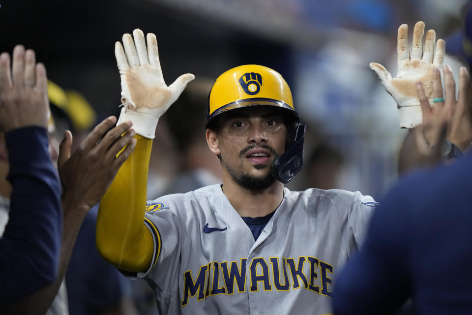 Milwaukee Brewers' Willy Adames is congratulated by teammates after he scored on a single by Brice Turang during the second inning of a baseball game against the Miami Marlins, Friday, Sept. 22, 2023, in Miami. (AP Photo/Wilfredo Lee)