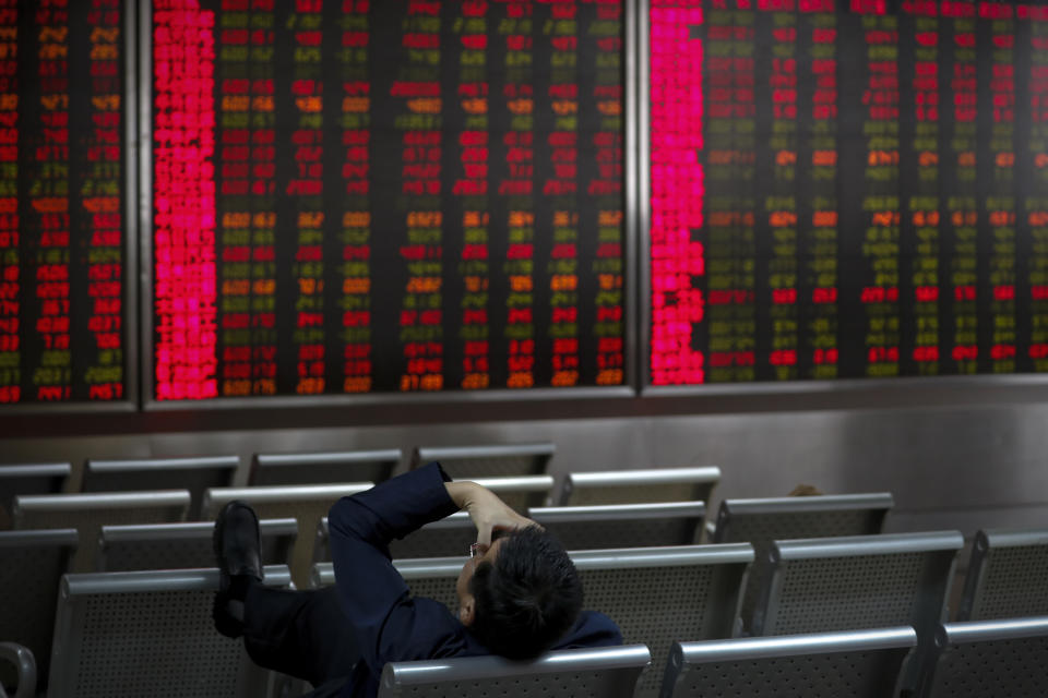 An investor presses his forehead in front of an electronic board displaying stock prices at a brokerage house in Beijing, Wednesday, Oct. 16, 2019. Asian shares were higher Wednesday after a gain on Wall Street boosted by healthy earnings reports from U.S. companies. (AP Photo/Andy Wong)