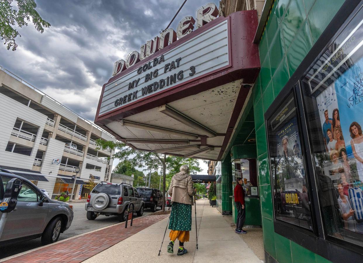 People walk past the Landmark Downer Theatre on Wednesday morning. The movie theater, Milwaukee's oldest, closed Tuesday night after more than a century of showing movies on Milwaukee's east side.