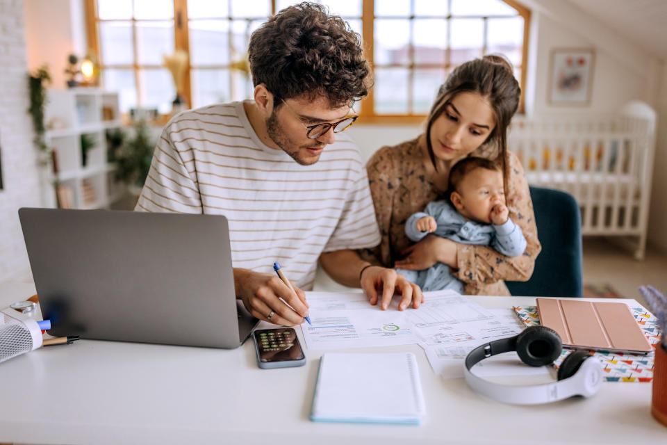 Young family with cute little baby boy going over finances at home tax