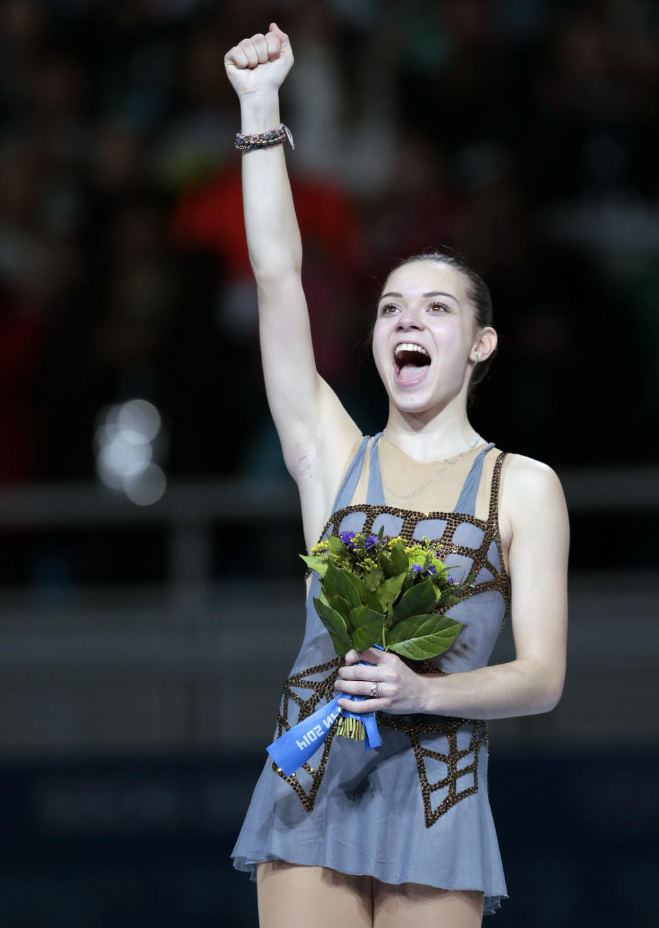 Adelina Sotnikova of Russia celebrates her first place as she stands on the podium during the flower ceremony for the women's free skate figure skating finals at the Iceberg Skating Palace during the 2014 Winter Olympics, Thursday, Feb. 20, 2014, in Sochi, Russia. (AP Photo/Ivan Sekretarev)