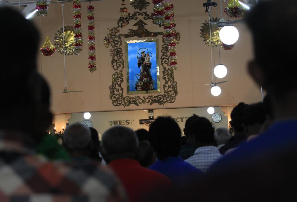 Devotees pray at a church during a special mass on Christmas day in Colombo