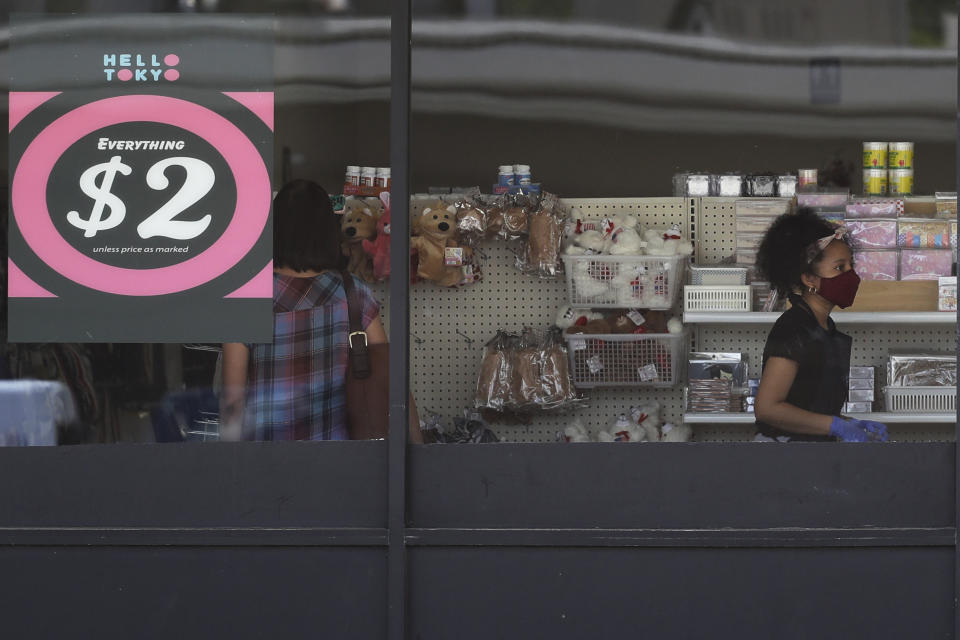 FILE - In this June 25, 2020 file photo, a price sign is displayed at a retail store as a store employee wears a mask while working in Niles, Ill. Small businesses are in limbo again as the coronavirus outbreak rages and the government’s $659 billion relief program draws to a close. Companies still struggling with sharply reduced revenue are wondering if Congress will give them a second chance at the Paycheck Protection Program, which ends Friday, Aug. 7, after giving out 5.1 million loans worth $523 billion. (AP Photo/Nam Y. Huh, File)