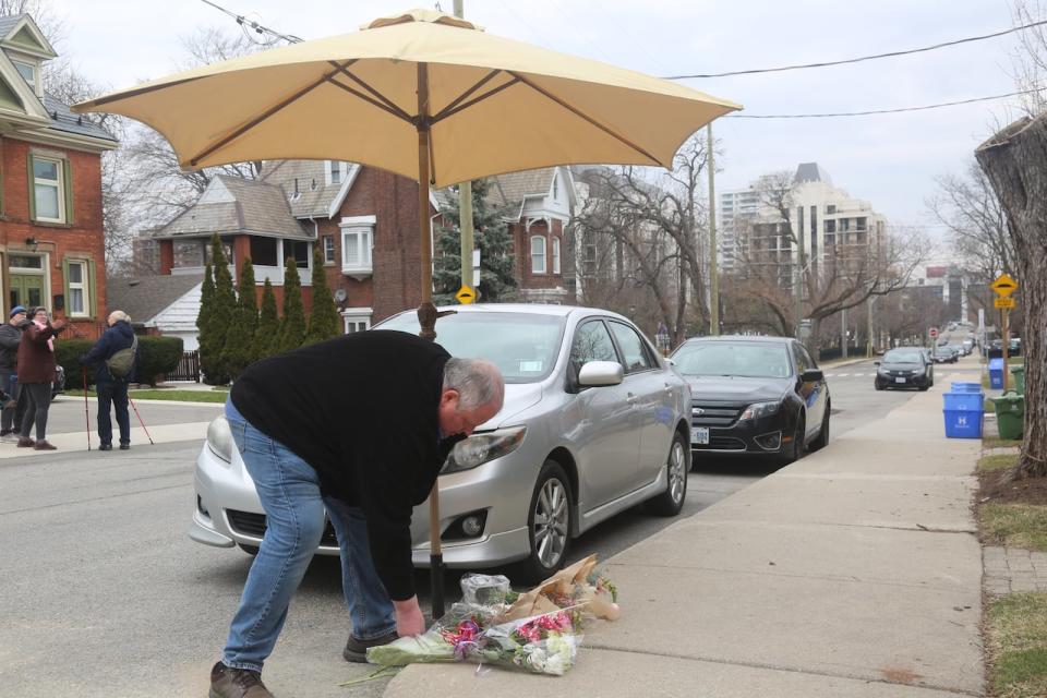 Carmine Posillipo tends to the memorial for Boris Brott that's growing in front of his home on Park Street South in Hamilton.