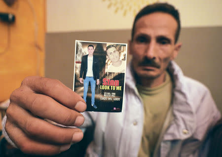 Father of one of 16 kidnapped Egyptians in Libya holds a picture of loved one at Al-Herda village in Kafr El Sheikh, Egypt November 20, 2018. Picture taken November 20, 2018. REUTERS/Mohamed Abd El Ghany