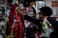 A man touches a figure of folk Saint "Gauchito" Gil at his sanctuary in Mercedes, Corrientes, Argentina, Sunday, Jan. 7, 2024. Every Jan. 8, devotees from across the country visit his sanctuary to ask for miracles or give him thanks.(AP Photo/Natacha Pisarenko)