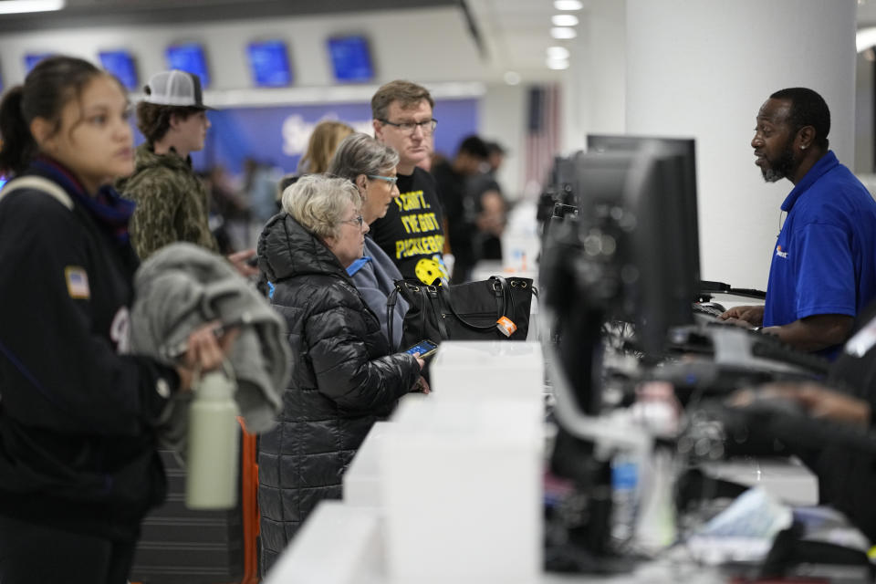 Travelers wait to speak to ticket agents at the Nashville International Airport, Tuesday, Nov. 21, 2023, in Nashville, Tenn. Despite inflation and memories of past holiday travel meltdowns, millions of people are expected to hit airports and highways in record numbers over the Thanksgiving Day break.(AP Photo/George Walker IV)