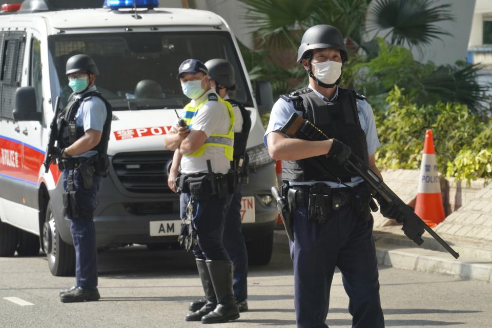 Police officers stand guard before a prison van carrying Hong Kong pro-democracy activist Andy Li leaves a court in Hong Kong, Wednesday, April 7, 2021. Li is one of the 12 young pro-democracy activists captured at sea last year by mainland Chinese authorities and returned to Hong Kong in March, as Li is charged with an offense under the newly-invented National Security Law. (AP Photo/Kin Cheung)