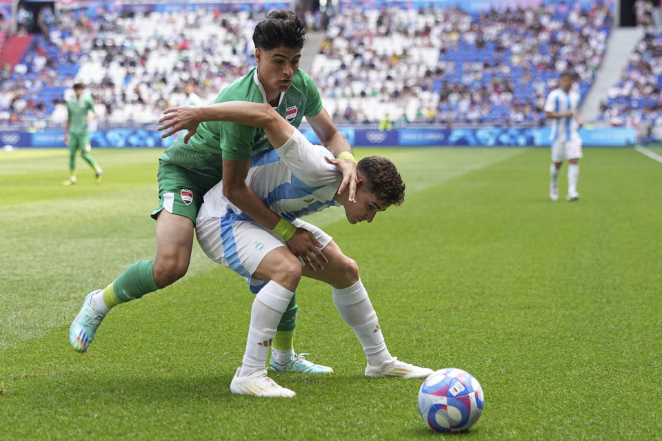 El delantero de Argentina Julian Álvarez, a la derecha, disputa la pelota con Hussein Hasan de Irak, a la izquierda, durante el partido por el Grupo B de los Juegos Olímpicos en el estadio Lyon, Francia, sábado 27 de julio de 2024. (AP Foto/Laurent Cipriani)