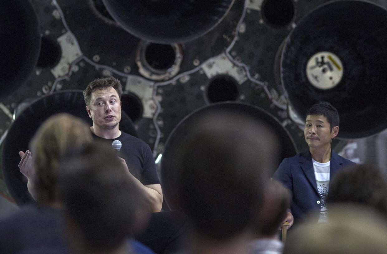 Elon Musk (L) and Japanese billionaire Yusaku Maezawa speak before a Falcon 9 rocket during the announcement that Maezawa will be the first private passenger who will fly around the Moon: DAVID MCNEW/AFP/Getty Images