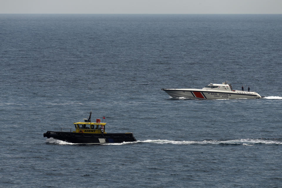 A boat with Russian, Ukrainian, Turkish and U.N. officials heads to the Sierra Leone-flagged cargo ship Razoni, to check if the grain shipment is in accordance with a crucial agreement signed last month by Moscow and Kyiv, at an inspection area in the Black Sea off the coast of Istanbul, Turkey, Wednesday, Aug. 3, 2022. The cargo ship Razoni, loaded up with 26,000 tons of corn, set sail from Ukraine's Odesa on Monday, enroute to final destination, Lebanon.(AP Photo/Emrah Gurel)