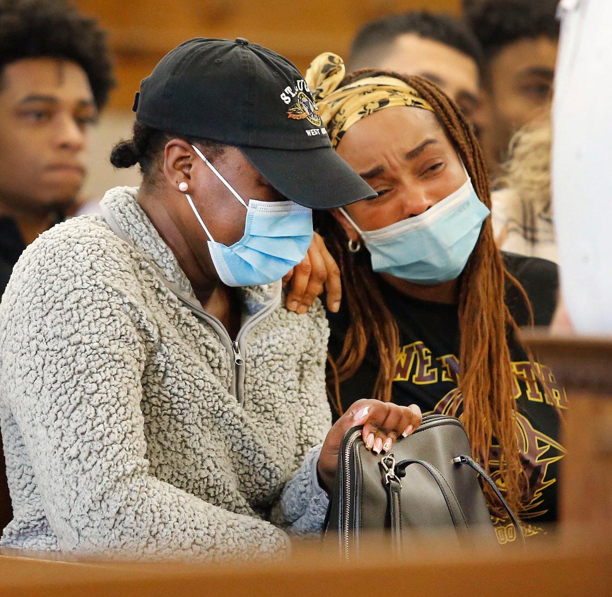 A woman identified as the mother of Nathan Paul, left, listens during the arraignment of her son's alleged killer, Keniel Diaz-Romero, in Dedham Superior Court.