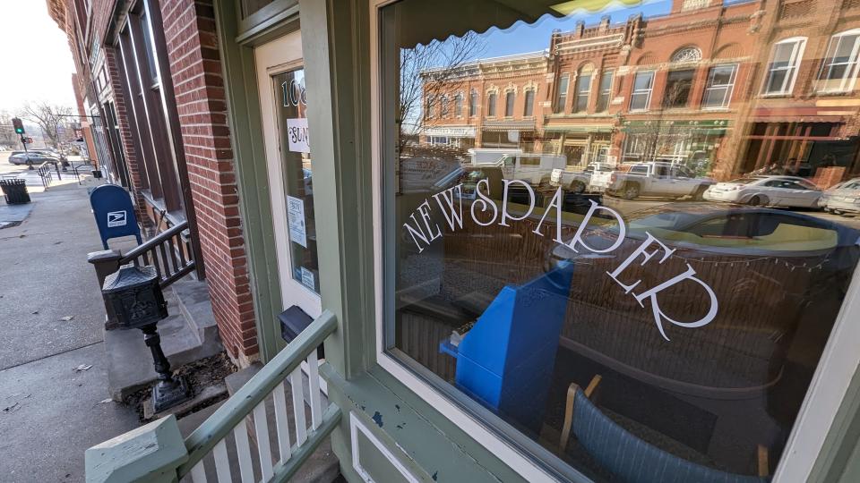 This quaint storefront window reflecting Main Street in downtown Mount Vernon identifies the office of the Mount Vernon-Lisbon Sun, one of two weekly newspapers recently purchased by the Daily Iowan, the University of Iowa student newspaper.