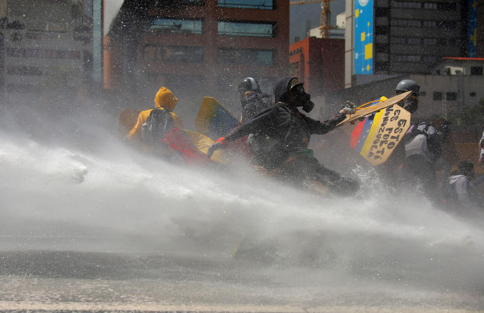 <p>Opposition supporters clash with riot security forces while rallying against President Nicolas Maduro in Caracas, Venezuela, May 18, 2017. (Carlos Barria/Reuters) </p>