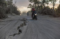 <p>Motorists ride past a road torn apart by Sunday’s earthquake in Gangga, Lombok Island, Indonesia, Saturday, Aug. 11, 2018. (Photo: Fauzy Chaniago/AP) </p>