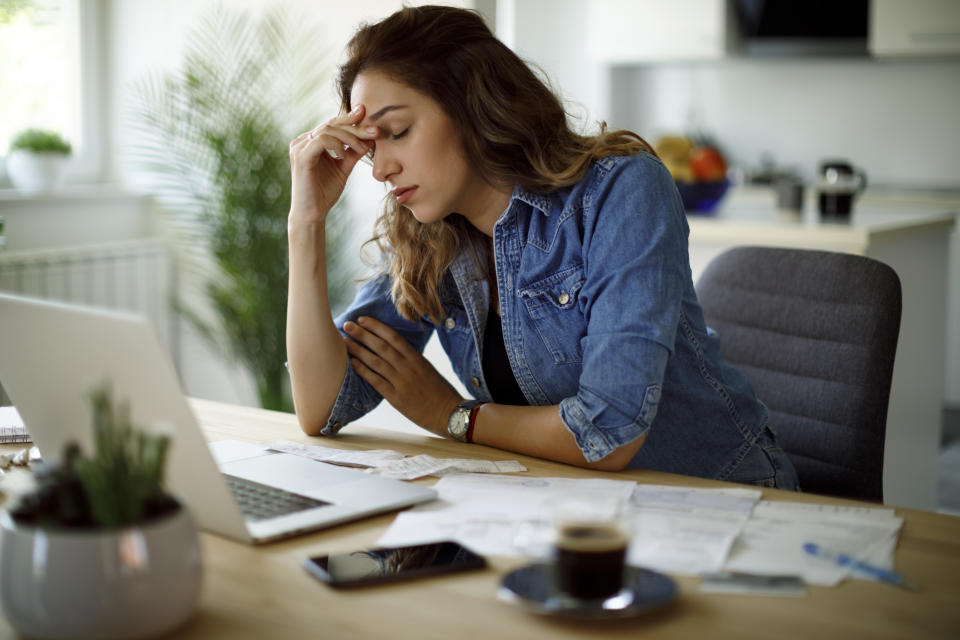 Worried young woman working at home