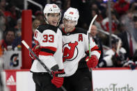 New Jersey Devils defenseman Damon Severson (28) celebrates his goal with defenseman Ryan Graves (33) during the second period of an NHL hockey game against the Washington Capitals, Saturday, March 26, 2022, in Washington. (AP Photo/Nick Wass)