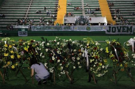 A woman places flowers before a mourning ceremony for victims after a plane carrying Brazil's soccer team Chapecoense crashed in Colombia, at Arena Conda stadium in Chapeco, Brazil, December 2, 2016. REUTERS/Diego Vara