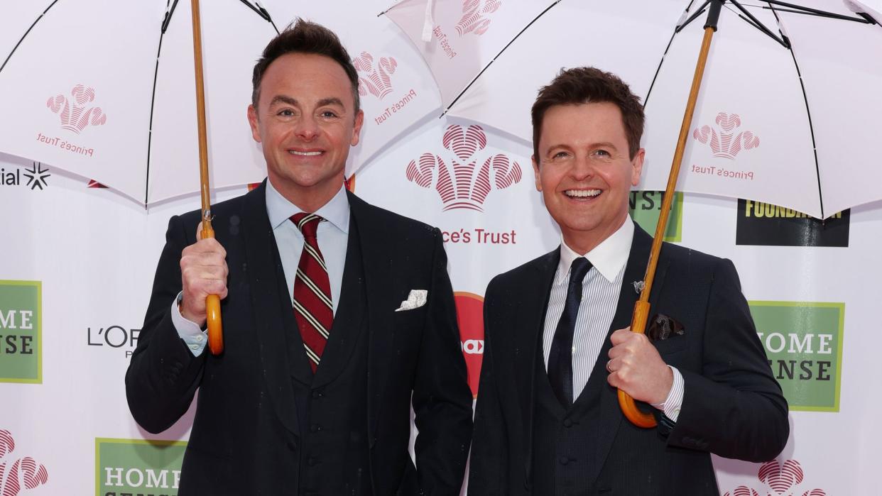 Ant and Dec in suits holding umbrellas