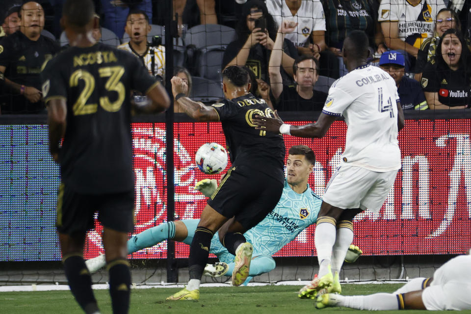 Los Angeles FC forward Denis Bouanga, second from left, scores on LA Galaxy goalkeeper Jonathan Bond during the first half of an MLS playoff soccer match Thursday, Oct. 20, 2022, in Los Angeles. (AP Photo/Ringo H.W. Chiu)