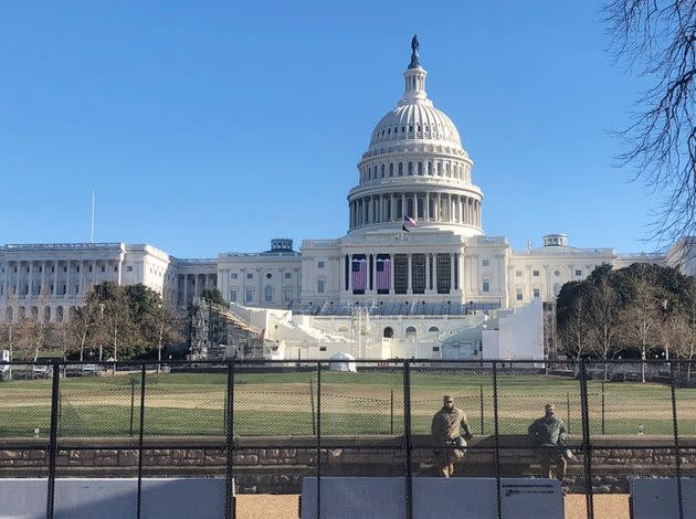 Members of the National Guard stand inside anti-scaling fencing that surrounds the Capitol on Sunday in Washington.