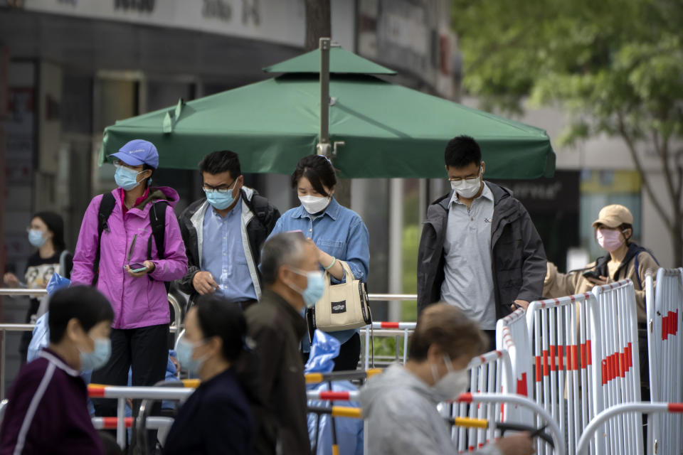 People wearing face masks stand in line for COVID-19 tests at a coronavirus testing site in Beijing, Wednesday, May 11, 2022. Shanghai reaffirmed China's strict "zero-COVID" approach to pandemic control Wednesday, a day after the head of the World Health Organization said that was not sustainable and urged China to change strategies. (AP Photo/Mark Schiefelbein)