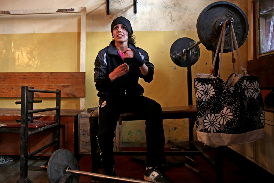 In this Wednesday, March, 5, 2014 photo, an Afghan female boxer prepares for practice at the Kabul Stadium boxing club. The Afghanistan National Olympic Committee boxing club has fewer than a dozen women and little money for them. Previously nongovernmental organizations supported them. At that time there were 25 young women who received a salary the equivalent of $100 per month and transportation to and from the Kabul Stadium where they train. (AP Photo/Massoud Hossaini)