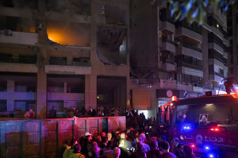 Bomberos libaneses se reúnen alrededor de un edificio blanco de una explosión que acabó con la vida del líder adjunto de Hamás, Saleh al-Arouri, y de otras seis personas.