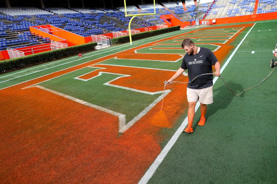 Ryan Linzmaier paints the south end zone of Steve Spurrier-Florida Field at Ben Hill Griffin Stadium on Thursday in preparation for the Gators' first game of the season on Saturday night against No. 8 Utah.