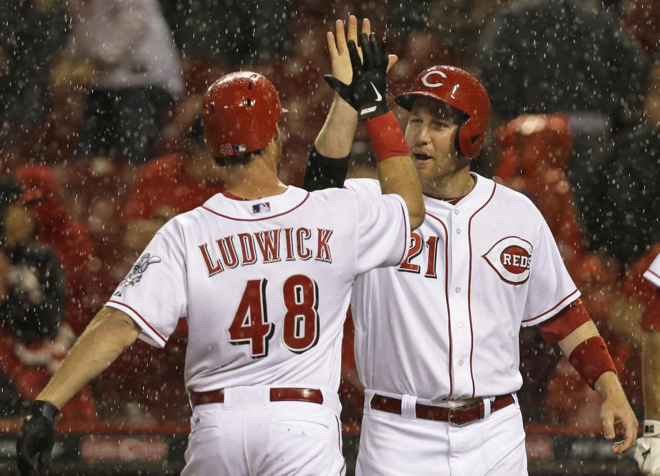 Cincinnati Reds' Ryan Ludwick (48) is congratulated by Todd Frazier (21) after Ludwick hit a two-run home run off Pittsburgh Pirates starting pitcher Wandy Rodriguez in the fourth inning of a baseball game being played in the rain, Monday, April 14, 2014, in Cincinnati. (AP Photo/Al Behrman)