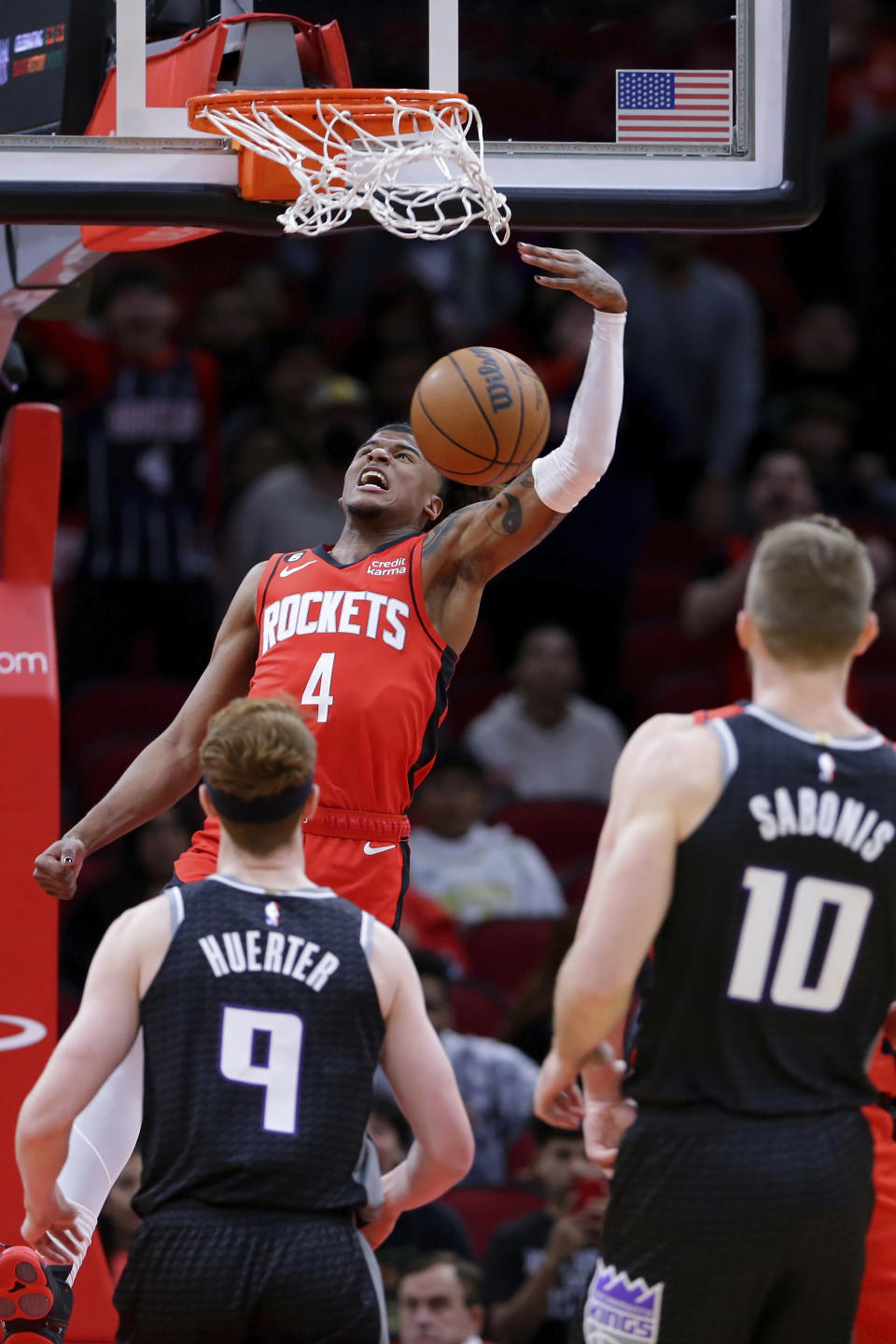 Houston Rockets guard Jalen Green (4) dunks in front of Sacramento Kings guard Kevin Huerter (9) and forward Domantas Sabonis (10) during the first half of an NBA basketball game Wednesday, Feb. 8, 2023, in Houston. (AP Photo/Michael Wyke)