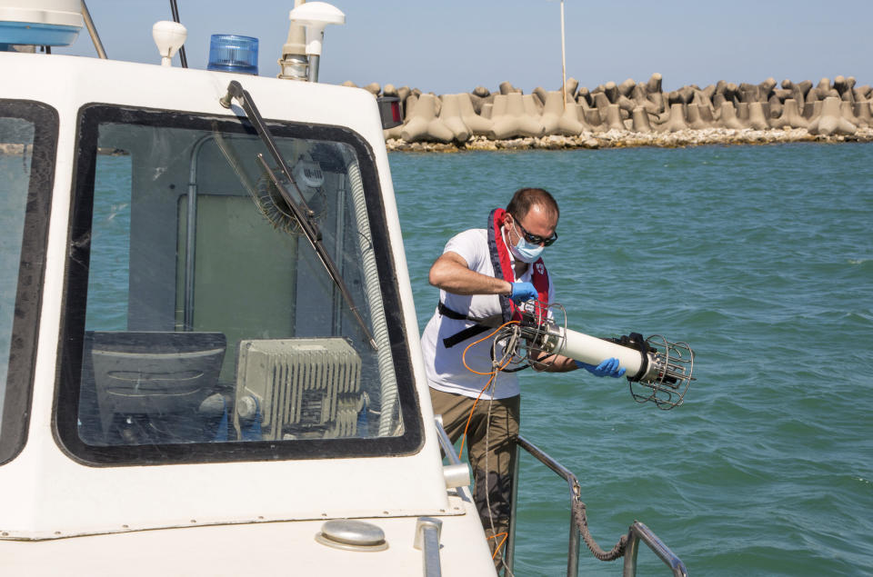 In this picture taken on Thursday, May 21, 2020, Italian Lazio region's environmental agency biologist Salvatore De Bonis shows how they perform tests on sea water during an interview with The Associated Press on a Coast Guard boat off Fiumicino, near Rome. Preliminary results from a survey of seawater quality during Italy’s coronavirus lockdown indicate a sharp reduction in pollution from human and livestock waste in the seas off Rome. Authorities stressed it was too soon to give the lockdown sole credit for the change. (AP Photo/Domenico Stinellis)