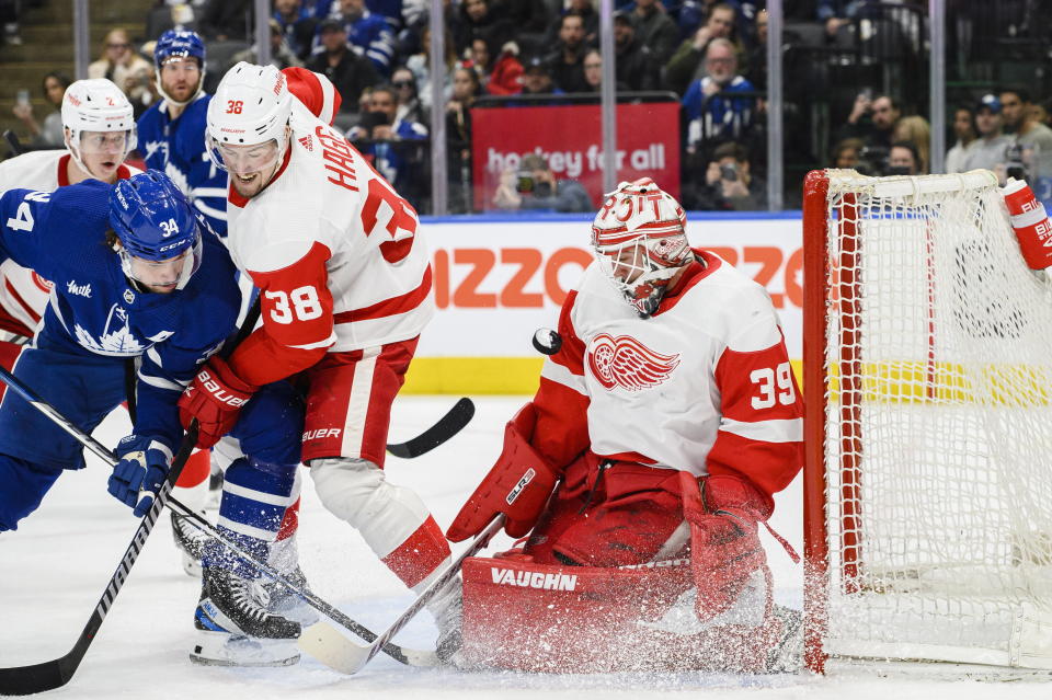 Detroit Red Wings goaltender Alex Nedeljkovic (39) makes a save against Toronto Maple Leafs center Auston Matthews as Red Wings defenseman Robert Hagg (38) battles in front of the netnduring the second period of an NHL hockey game in Toronto on Sunday, April 2, 2023. (Christopher Katsarov/The Canadian Press via AP)