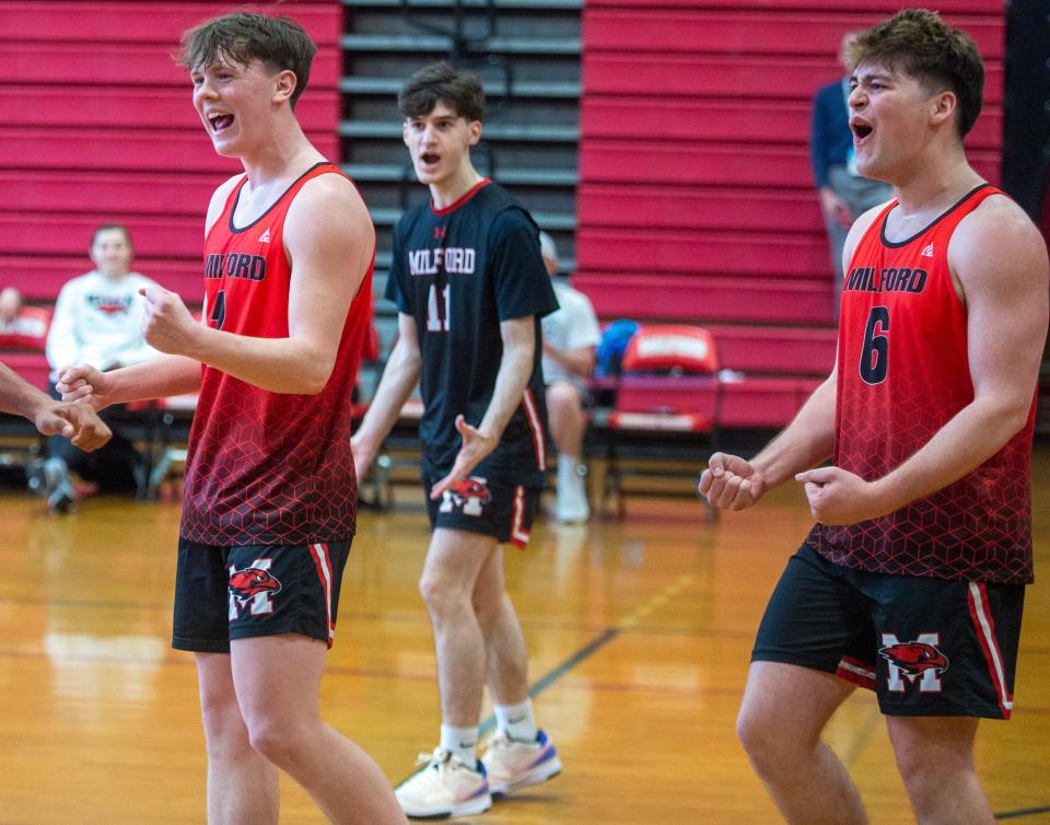 Milford High School boys volleyball seniors Owen Callahan, Alex Doiron, and captain Arthur Gomes celebrate a point against Lexington, April 18, 2024.