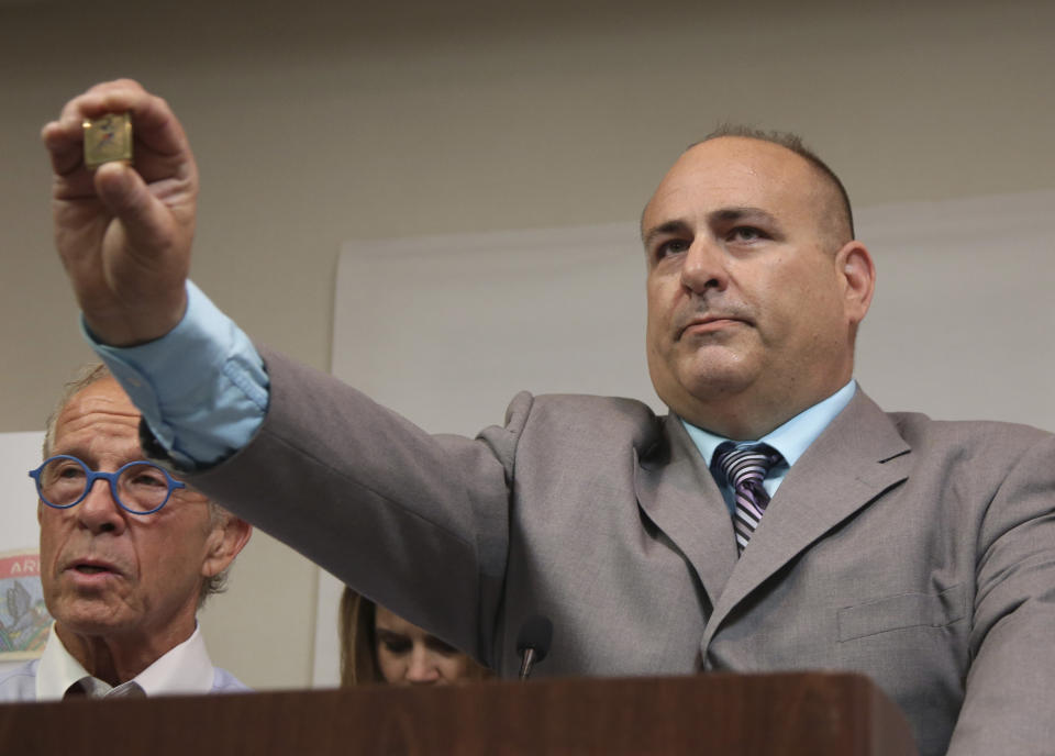 Richard Halvorson holds up a physical fitness badge, used by the Boy Scouts of America, during a news conference in Newark, N.J., Tuesday, April 30, 2019. Halvorson is alleging sexual abuse in a lawsuit filed against the Boy Scouts of America. The abuse occurred under the guise of trying to earn the fitness badge when Halvorson was an 11-year-old boy scout. (AP Photo/Seth Wenig)