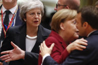 British Prime Minister Theresa May, center, arrives for a round table meeting at an EU summit in Brussels, Thursday, Dec. 13, 2018. EU leaders gathered Thursday for a two-day summit which will center on the Brexit negotiations. At right is French President Emmanuel Macron greeting German Chancellor Angela Merkel. (AP Photo/Alastair Grant)