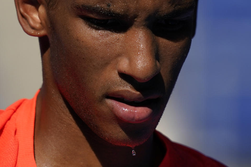 Sweat drips off the chin of Felix Auger-Aliassime, of Canada, as he plays against Max Purcell, of Australia, during the first round of the tennis competition at the 2020 Summer Olympics, Sunday, July 25, 2021, in Tokyo, Japan. (AP Photo/Seth Wenig)