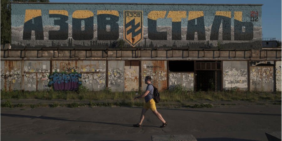 A man walks past a mural with the inscription Azovstal in honor of the defenders of Mariupol in Kiev