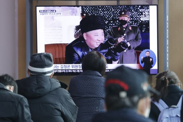 People watch a TV showing a file image of North Korean leader Kim Jong Un