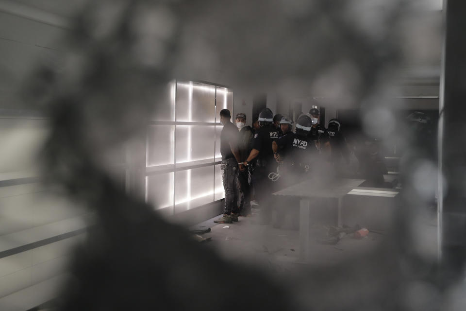 New York police officers arrest people inside a vandalized Balenciaga store in New York, June 2, 2020, during street protests over the death of George Floyd. The image was part of a series of photographs by The Associated Press that won the 2021 Pulitzer Prize for breaking news photography. (AP Photo/Frank Franklin II)