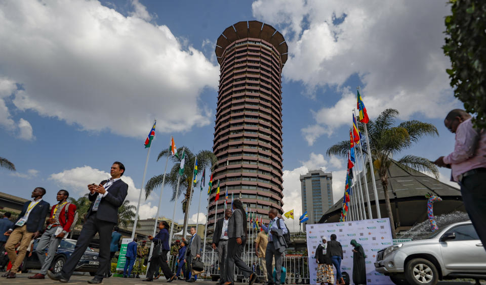 Delegates walk outside the Kenyatta International Convention Centre (KICC) in Nairobi, Kenya, Tuesday Sept. 5, 2023, during the Africa Climate Summit. The summit's opening speeches included clear calls to reform the global financial structures that have left African nations paying about five times more to borrow money than others, worsening the debt crisis for many. (AP Photo/Brian Inganga)